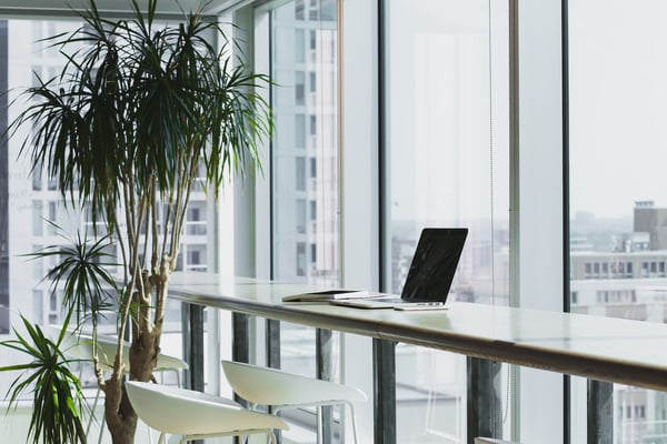 laptop on a desk near a window